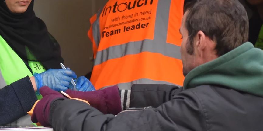 Photo of a volunteer giving food to someone